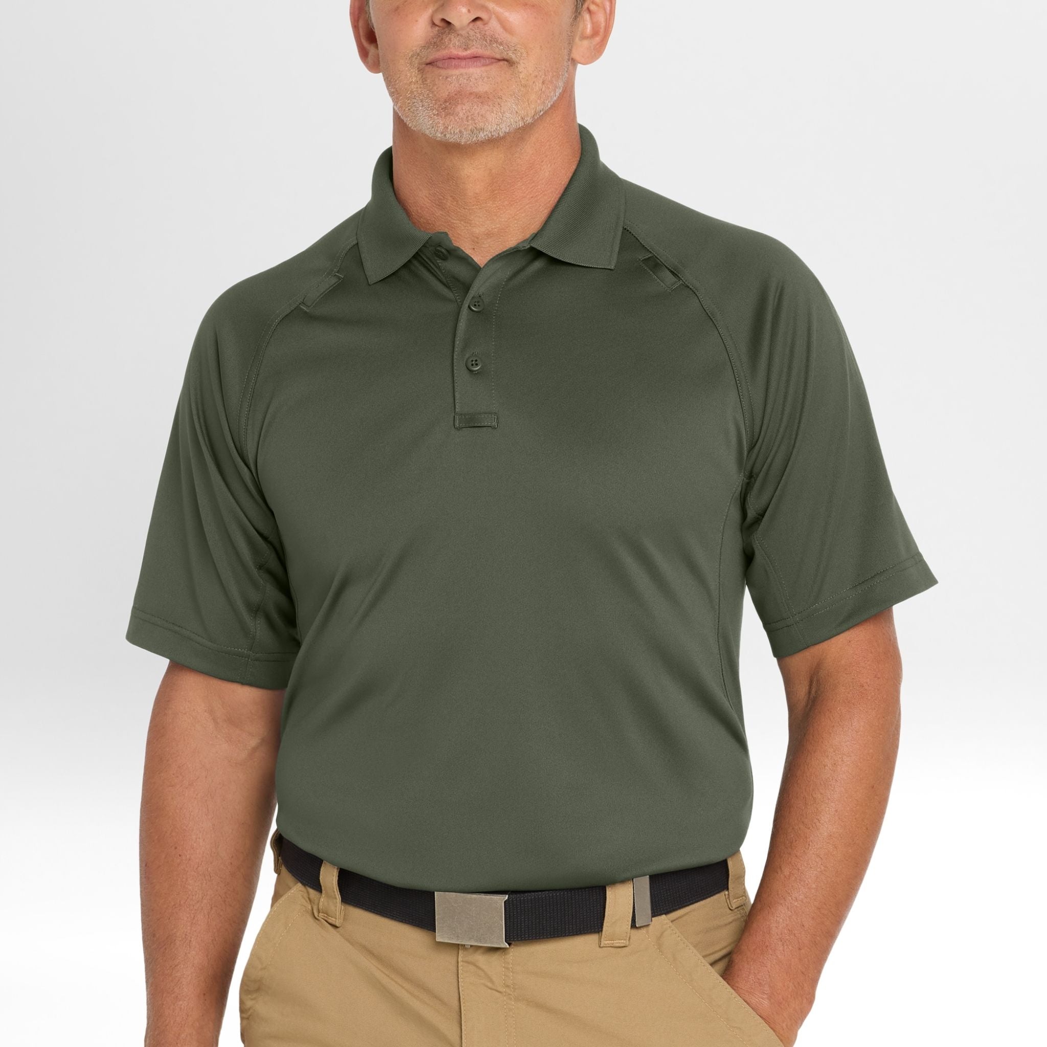 Man wearing a green Snag-Proof Tactical Polo shirt and beige pants on a white background