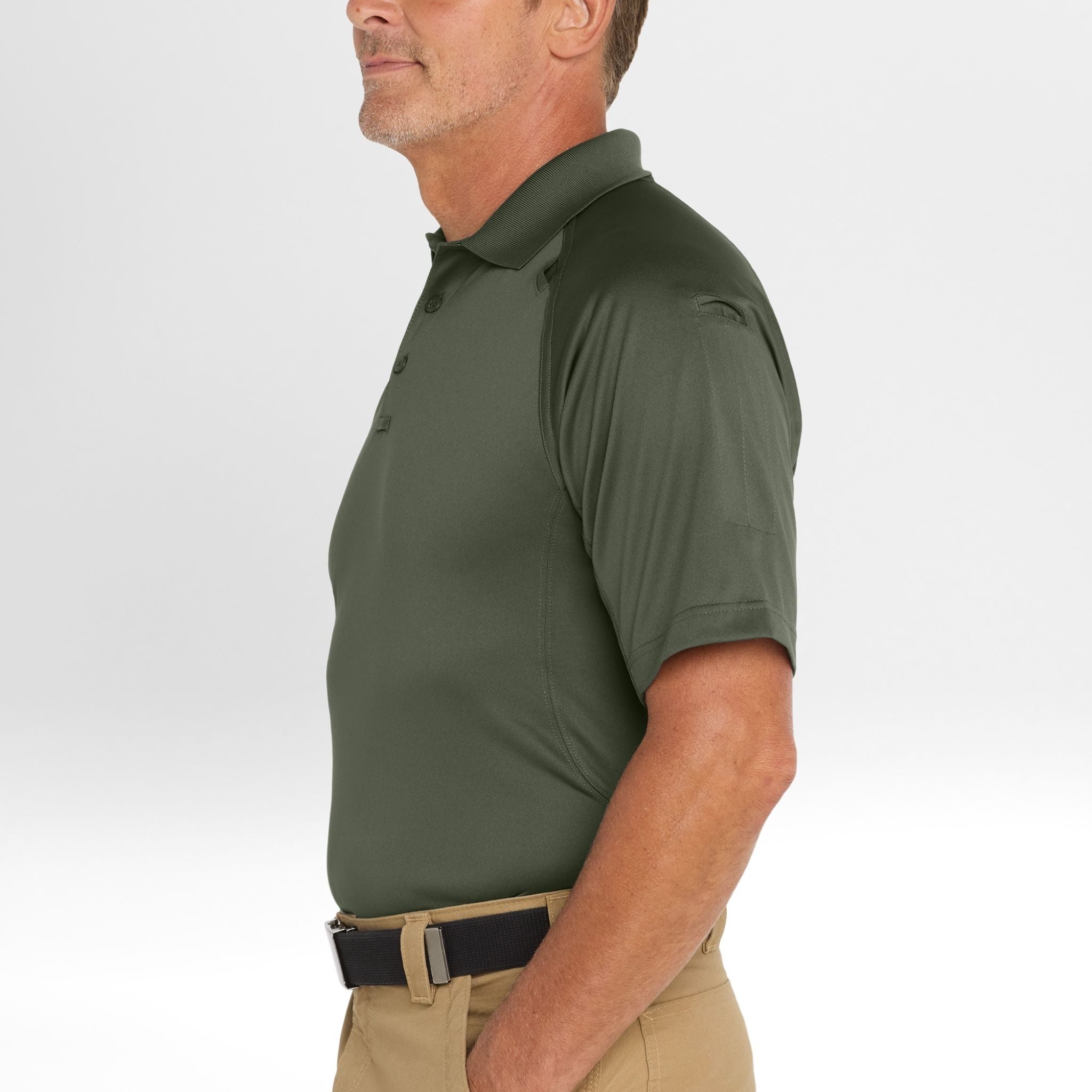 Man wearing a green Snag-Proof Tactical Polo shirt and beige pants on a white background