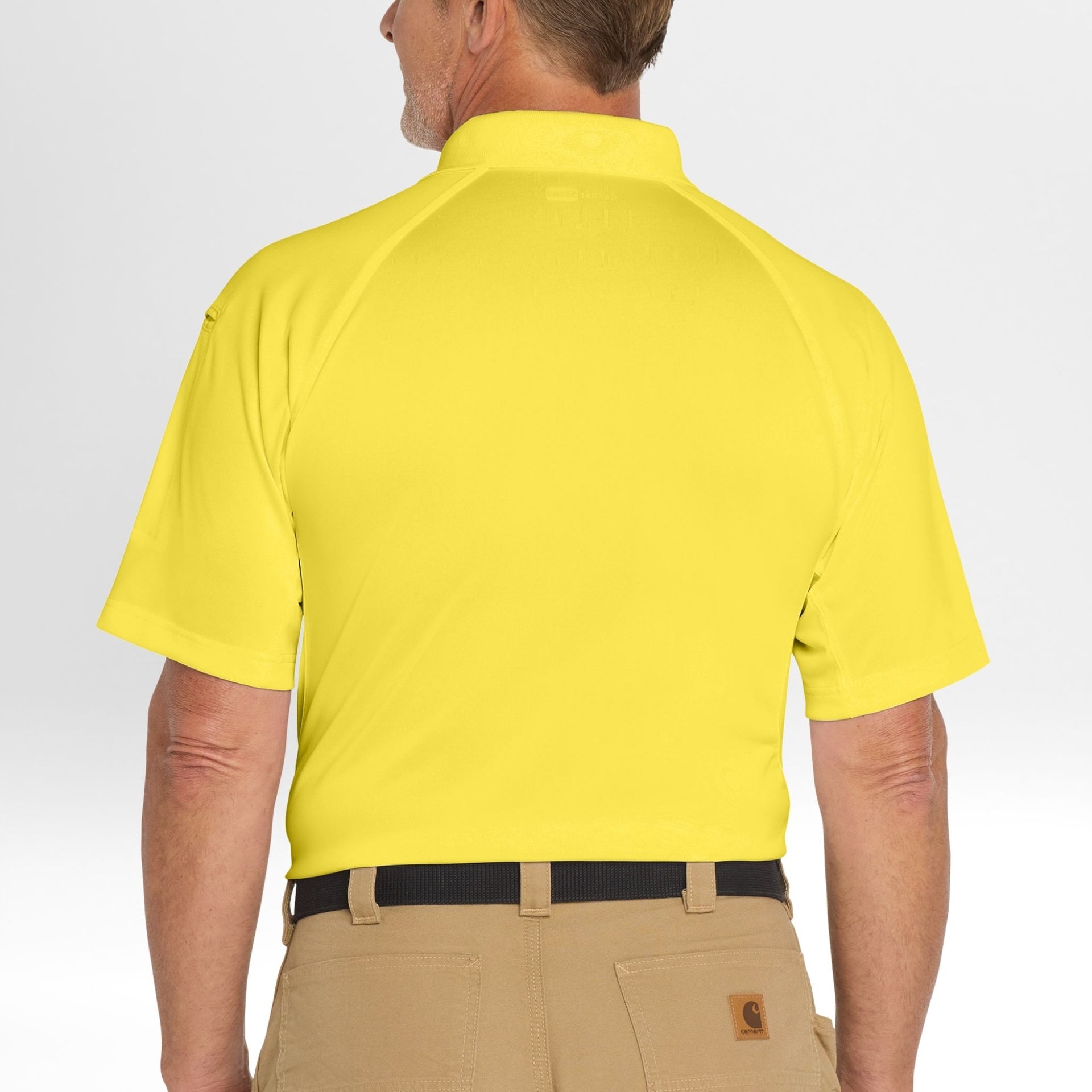 Person wearing a yellow Snag-Proof Tactical Polo shirt and beige pants on a white background
