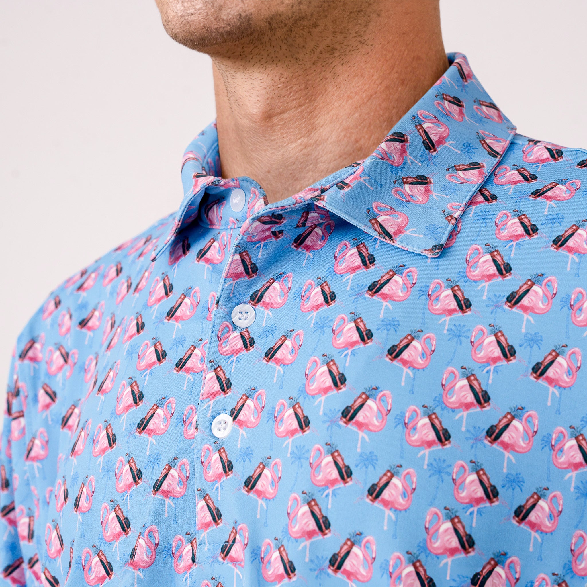 Close-up of a blue shirt with pink flamingo wearing a golf bag