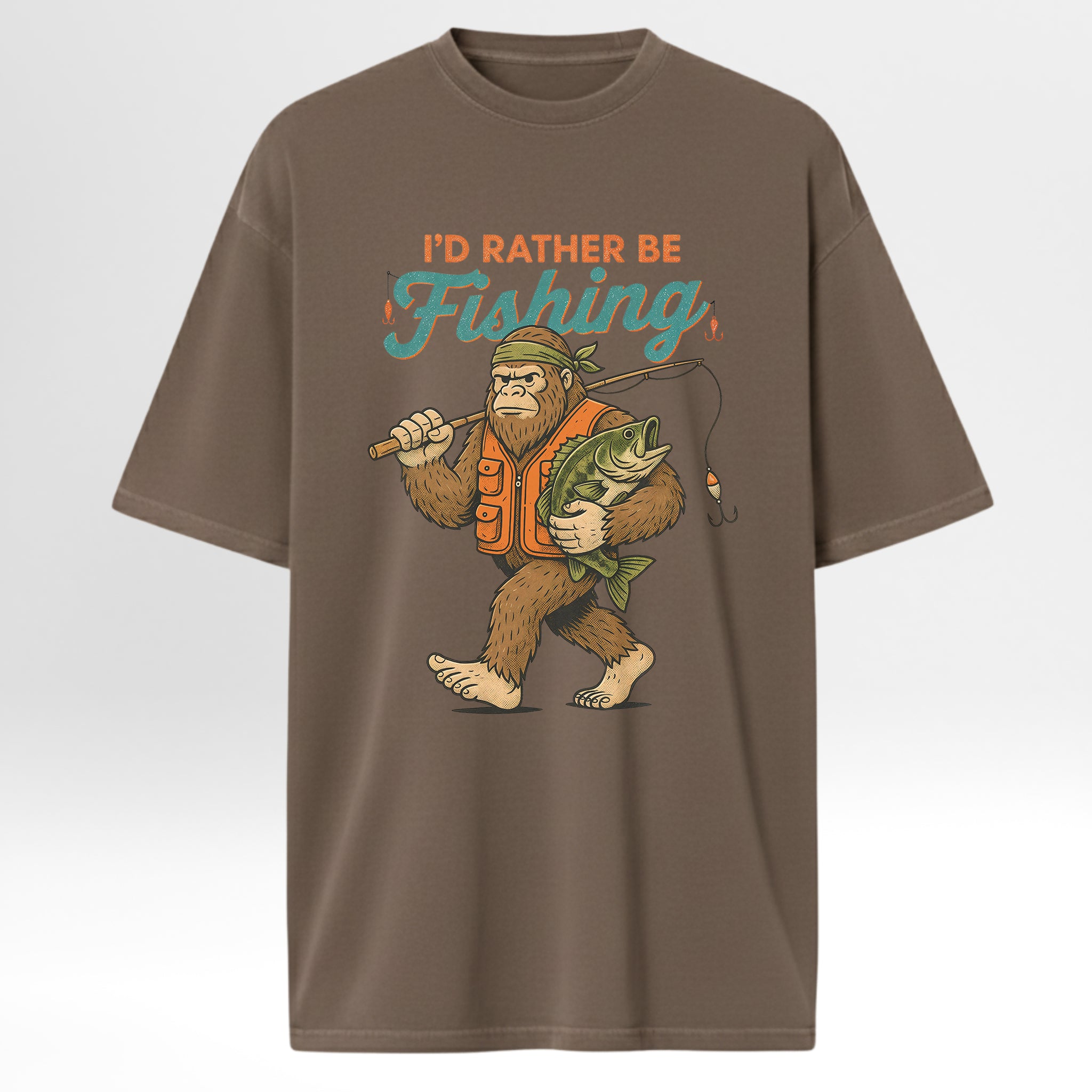 Brown fishing t-shirt with a graphic of a bigfoot holding a fish and text 'I'd Rather Be Fishing'.