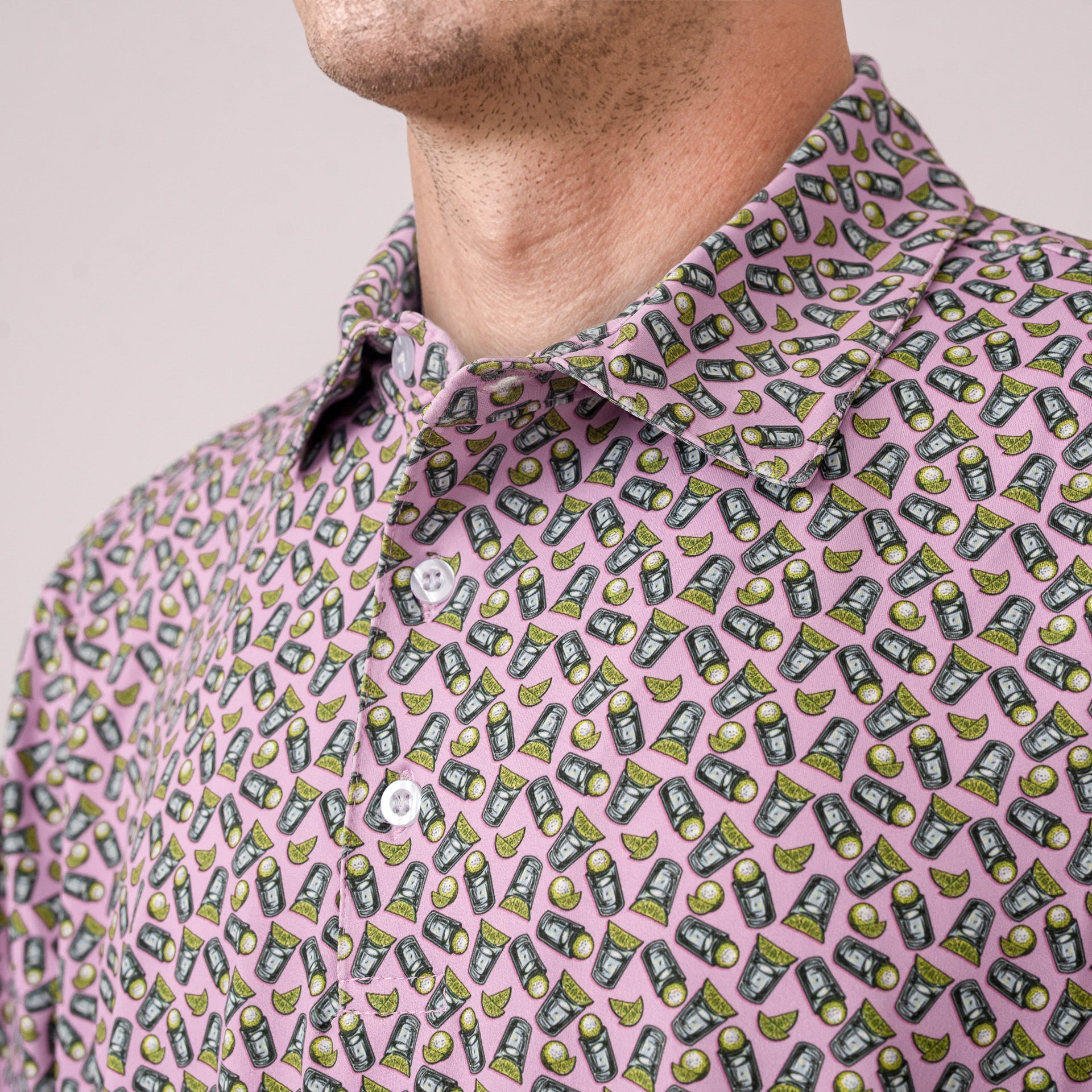 Close-up of a person wearing a pink shirt with a pattern of tequila shot and lime