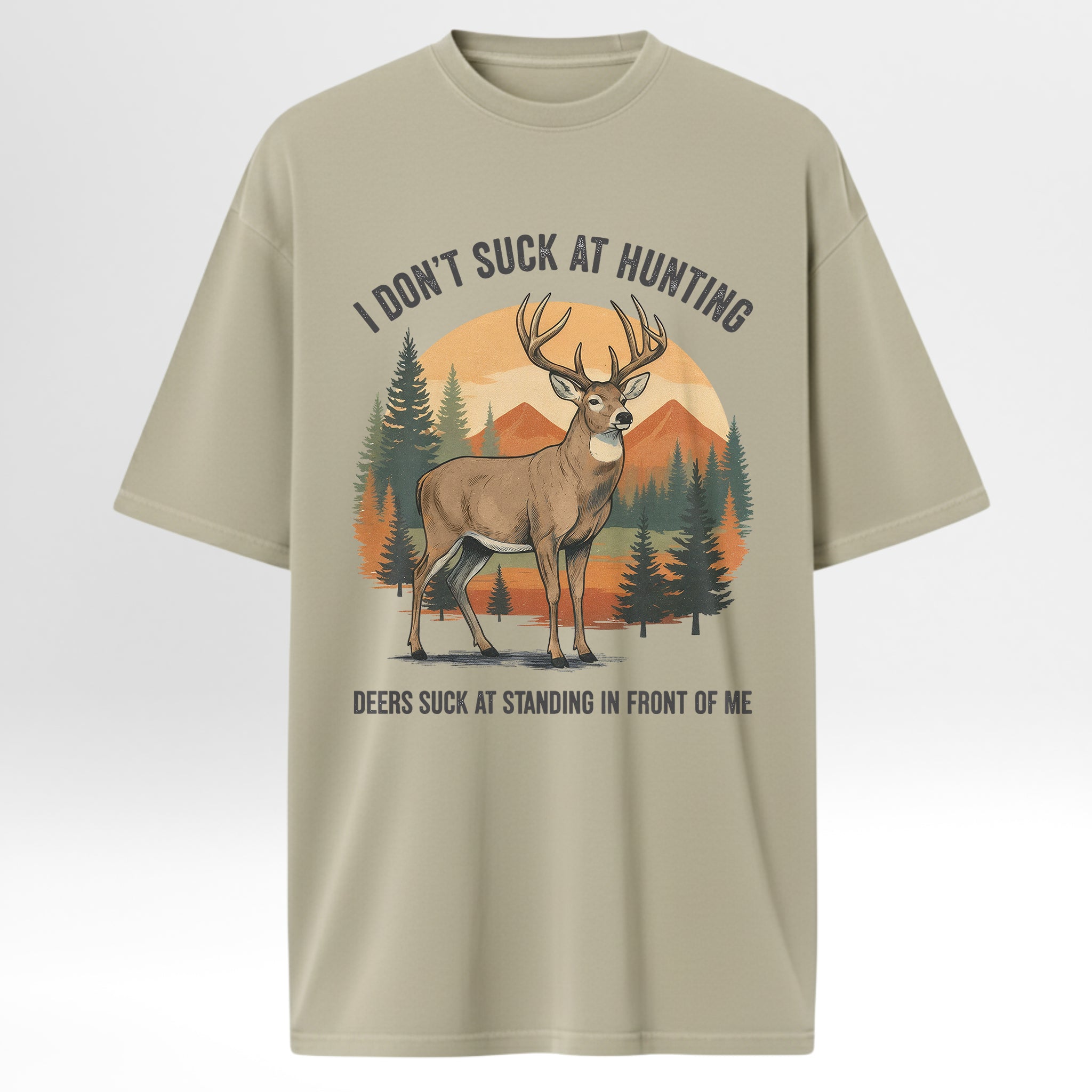 Beige hunting t-shirt with a graphic of a deer and text 'I Don't Suck At Hunting Deers Suck At Standing In Front Of Me'.