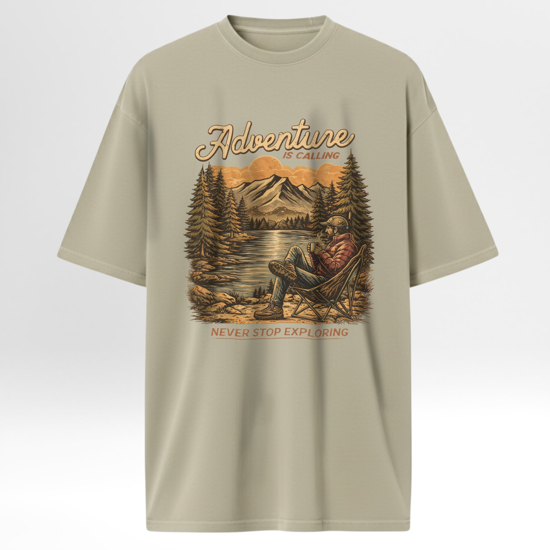 Beige t-shirt with a graphic of a person in a chair by a lake and mountains, with 'Adventure is Calling, Never Stop Exploring' text.