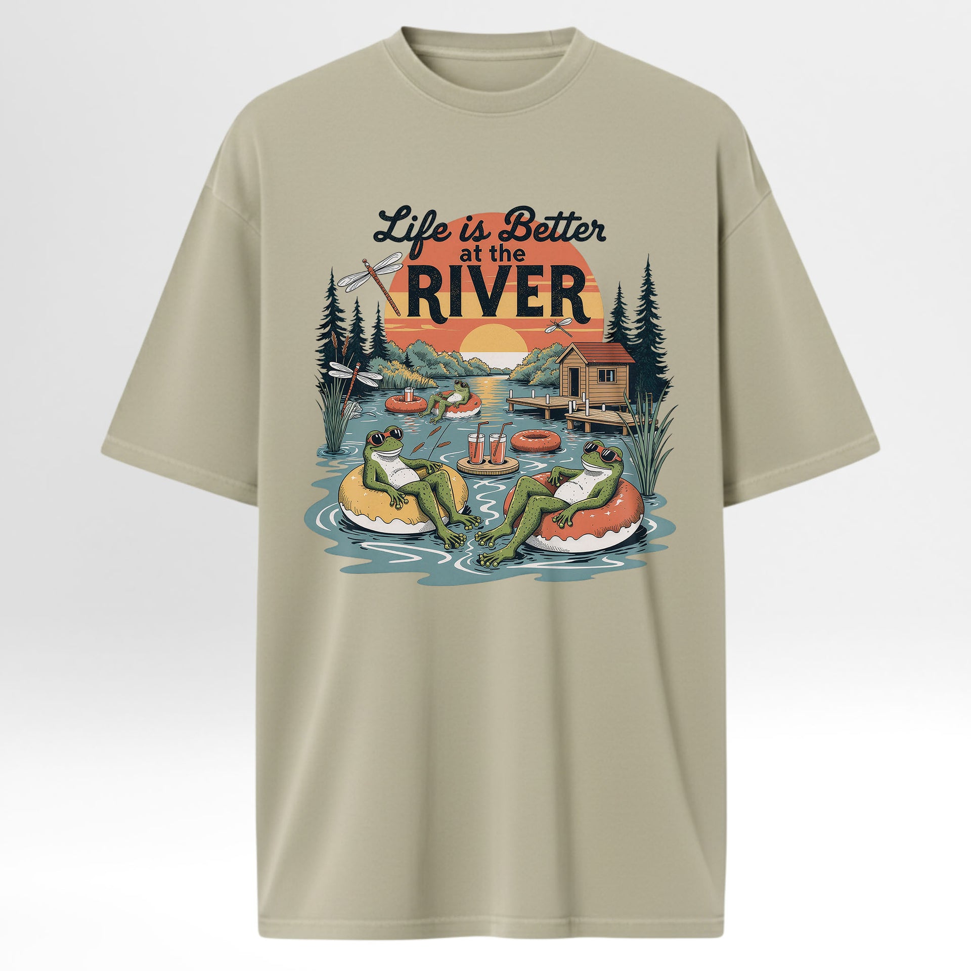 Beige t-shirt with 'Life is Better at the River' graphic design featuring frogs and a cabin.