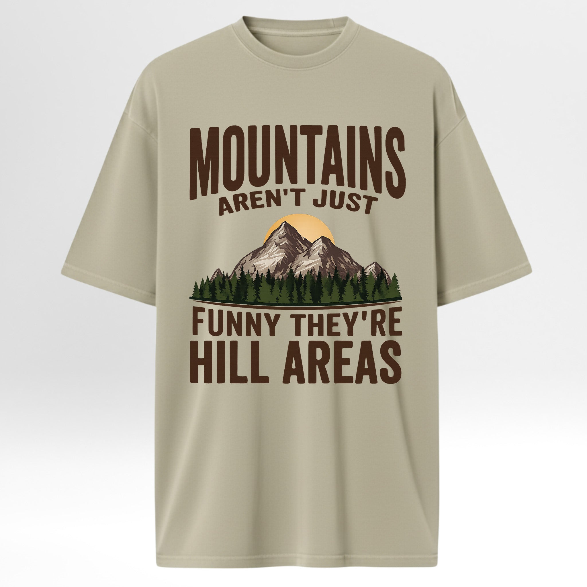 Beige t-shirt with mountain graphic and humorous text 'Mountains Aren't Just Funny They 're Hill Areas'