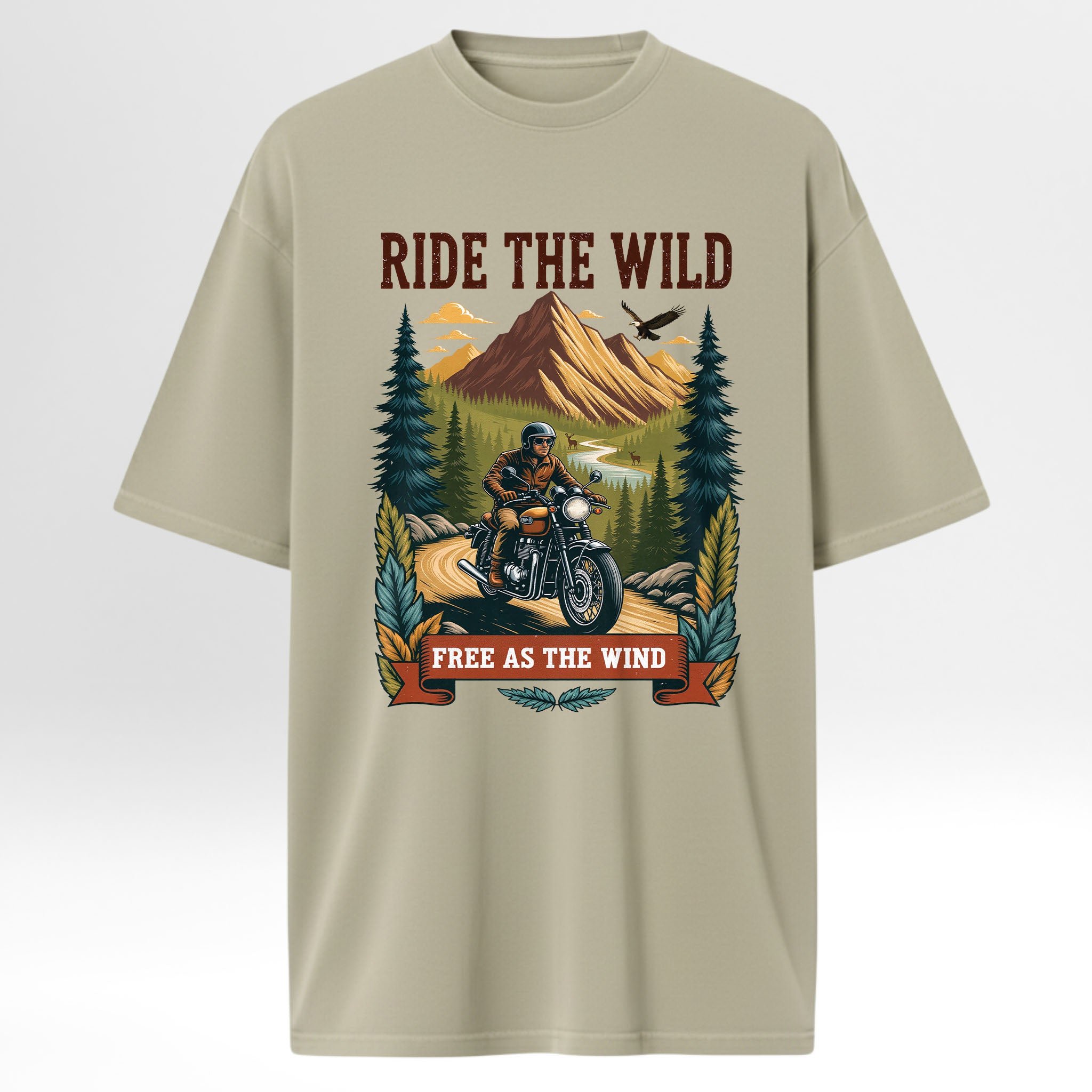 Beige trail graphic t-shirt with a graphic of a person on a motorcycle in a forest and mountains, with text 'Ride the Wild Free as the Wind'.
