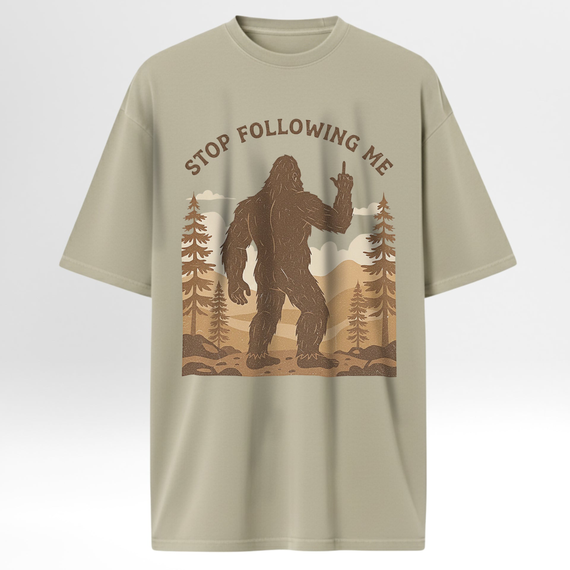 Beige outdoor t-shirt with a graphic of a Sasquatch and text 'Stop Following Me'.