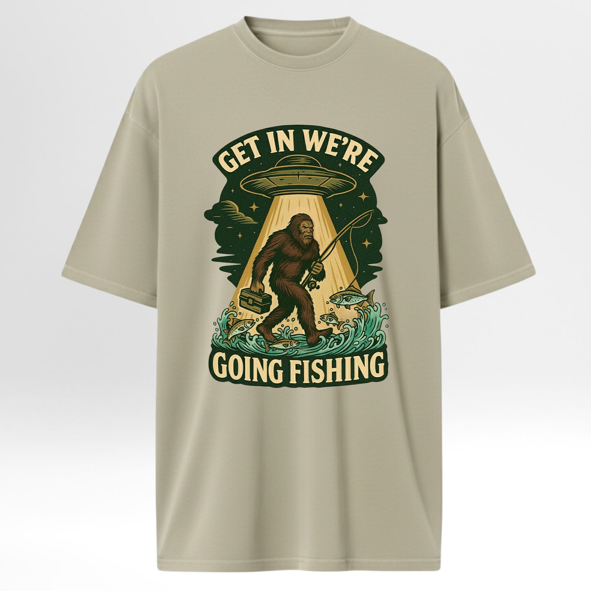 Beige fishing t-shirt with a graphic design featuring a Sasquatch, UFO, and text 'Get In We're Going Fishing'