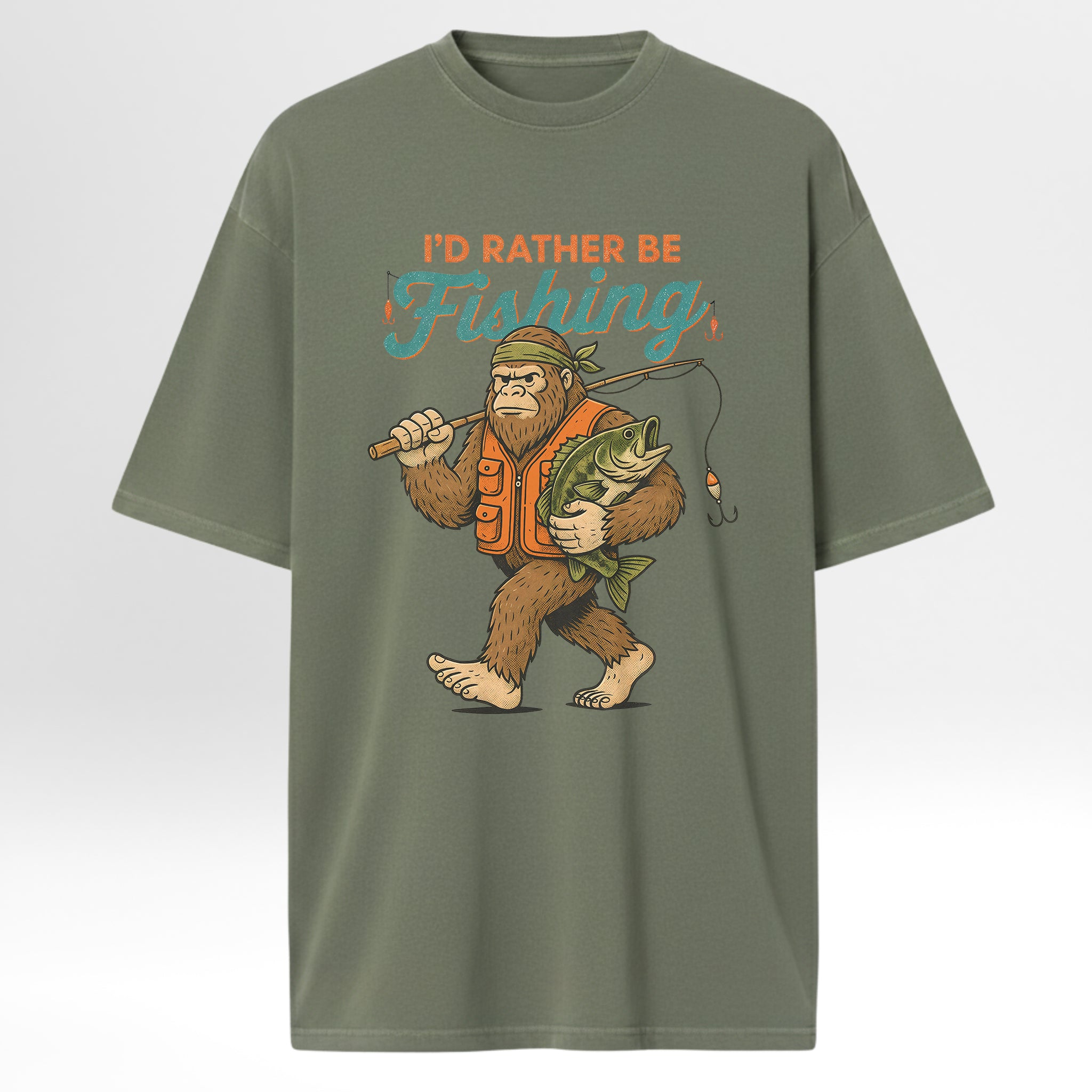 Green fishing t-shirt with a graphic of a bigfoot holding a fish and a fishing rod, with text 'I'd Rather Be Fishing'.