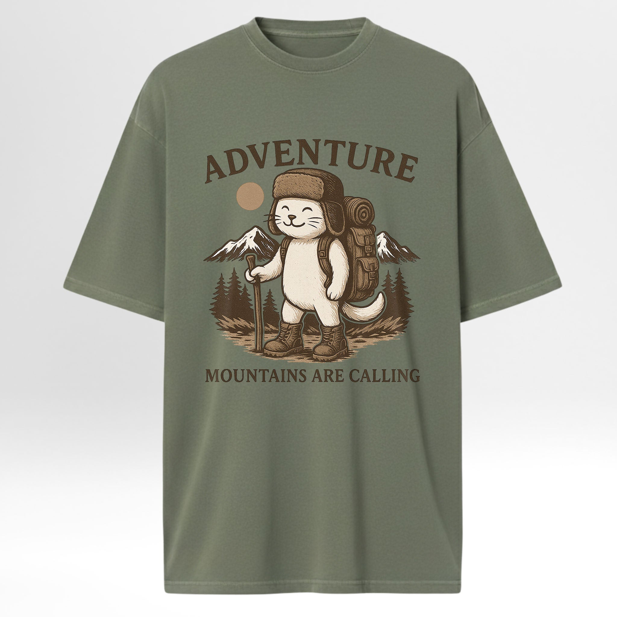 Green trail graphic t-shirt with a graphic of a cat in a hat and backpack with 'Adventure Mountains Are Calling' text on a white background.