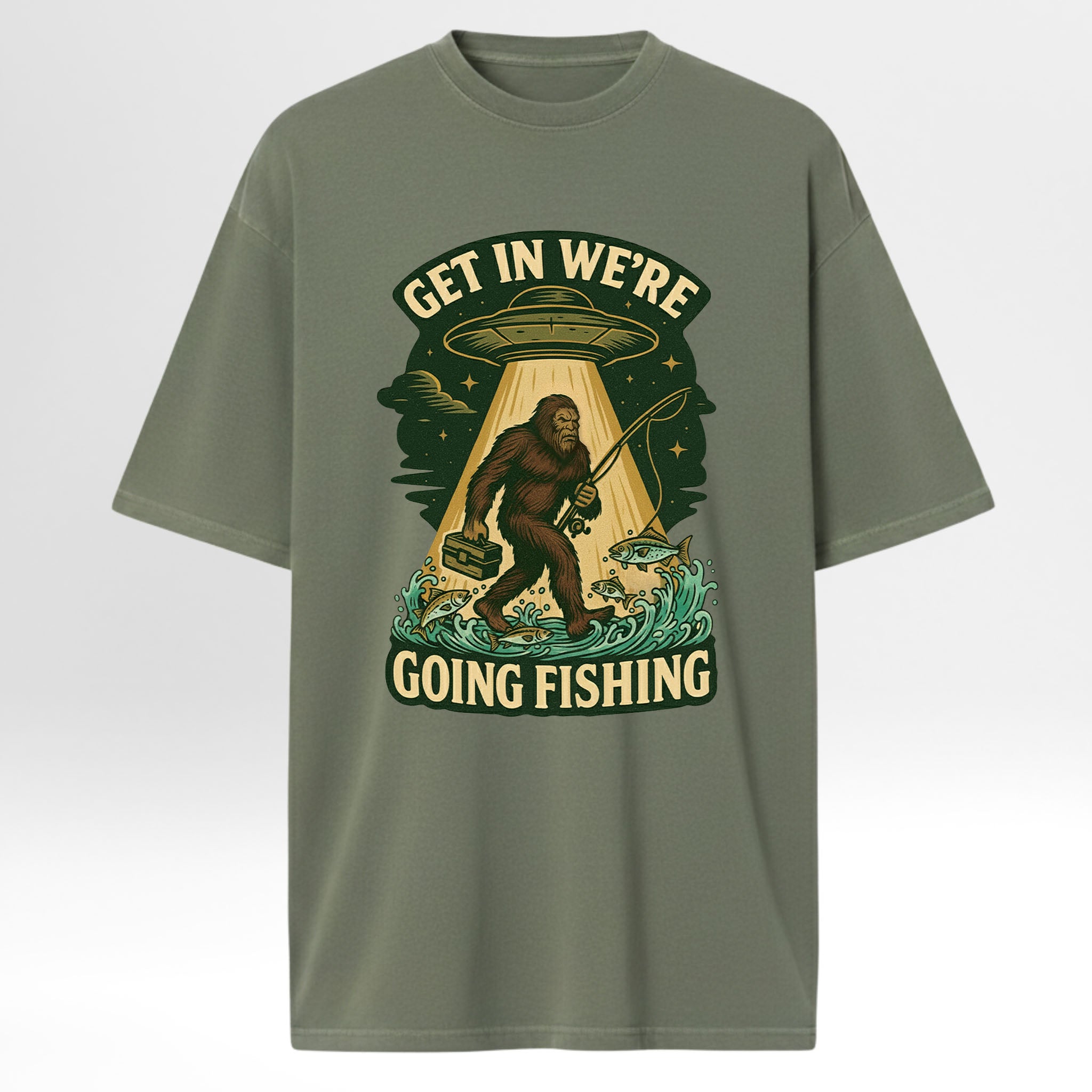 Green fishing t-shirt with a graphic design featuring a Sasquatch, UFO, and text 'Get In We're Going Fishing'
