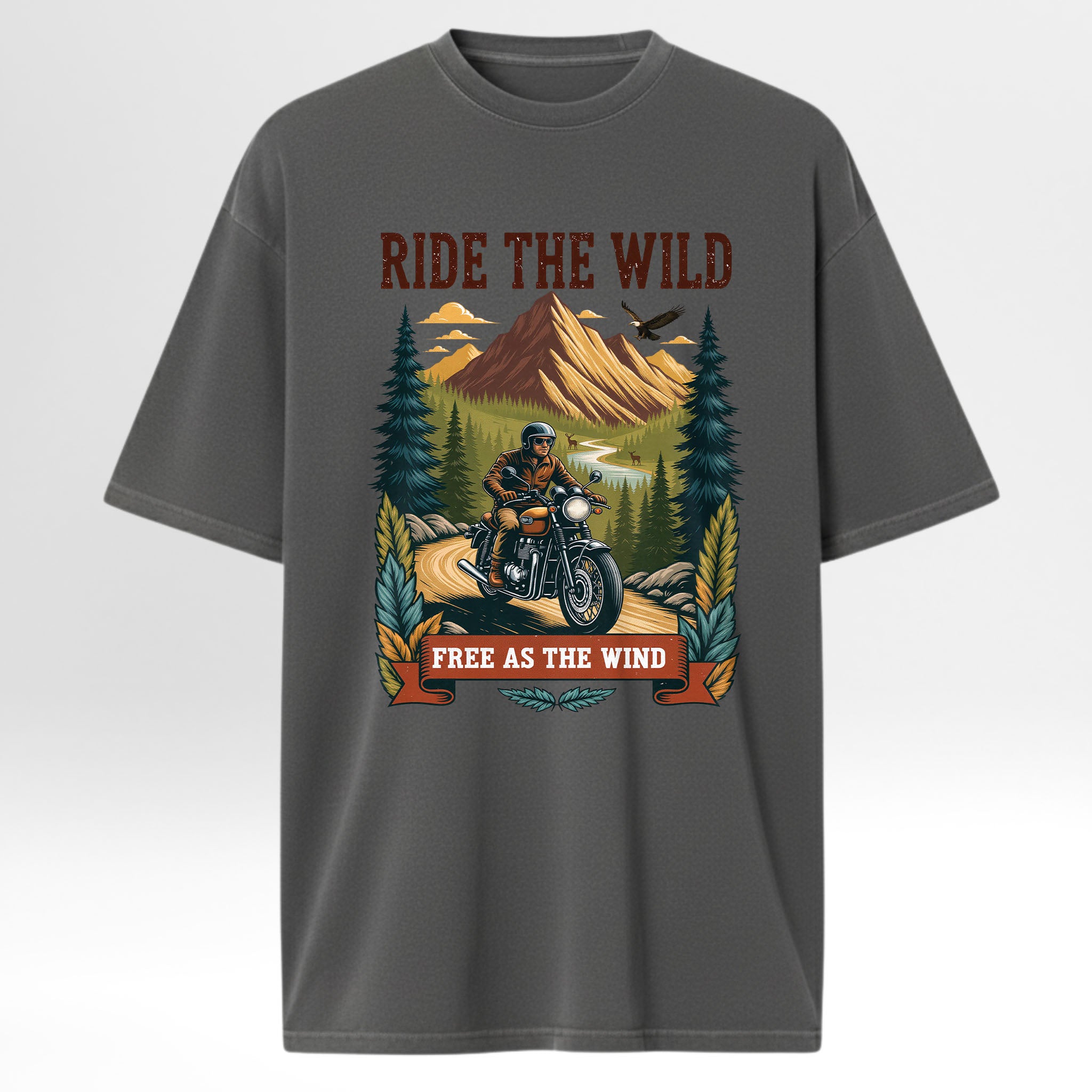 Gray trail graphic t-shirt with a graphic of a person on a motorcycle in the wilderness and text 'Ride the Wild, Free as the Wind' on a white background.