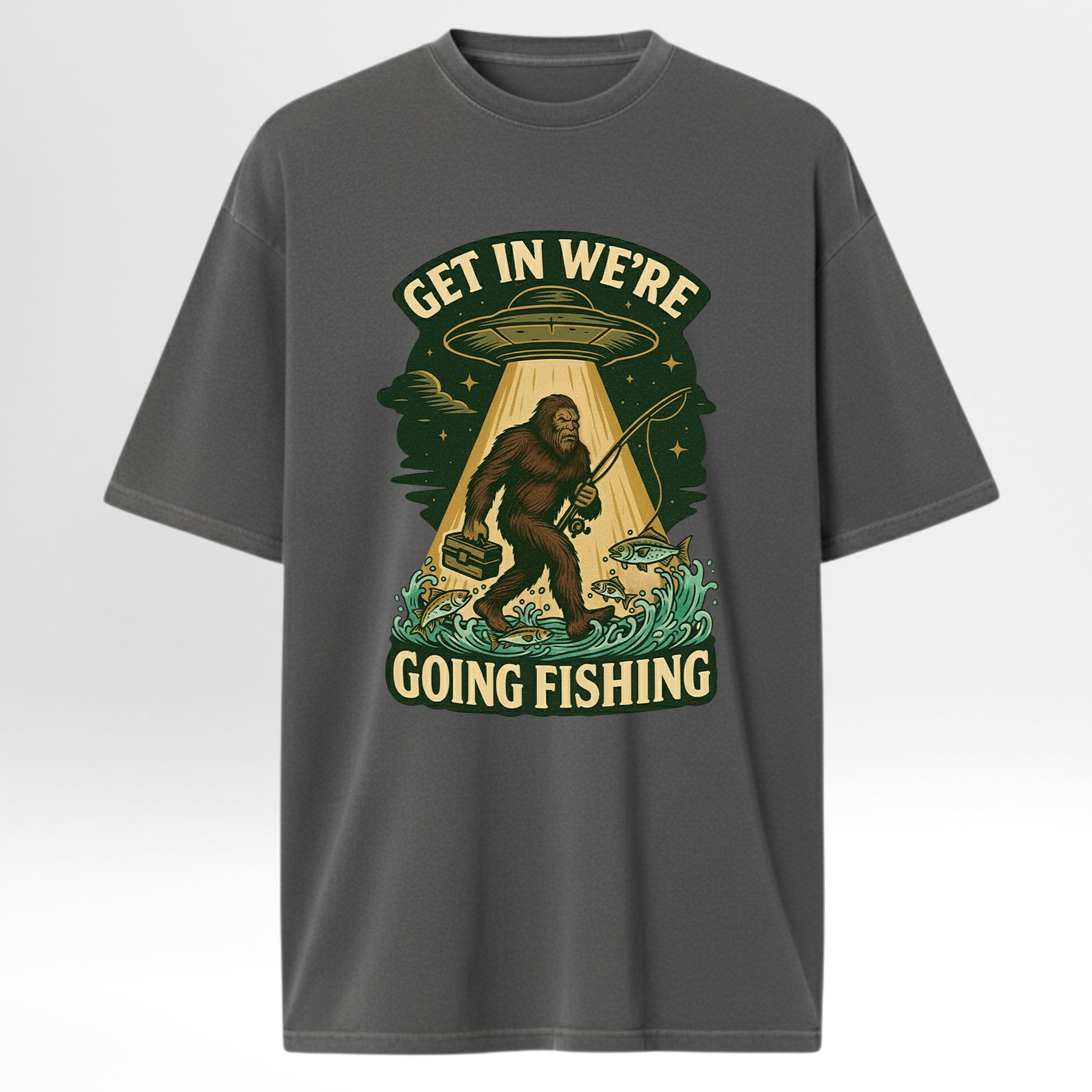 Gray fishing t-shirt with a graphic design featuring a Sasquatch, UFO, and text 'Get In We're Going Fishing'
