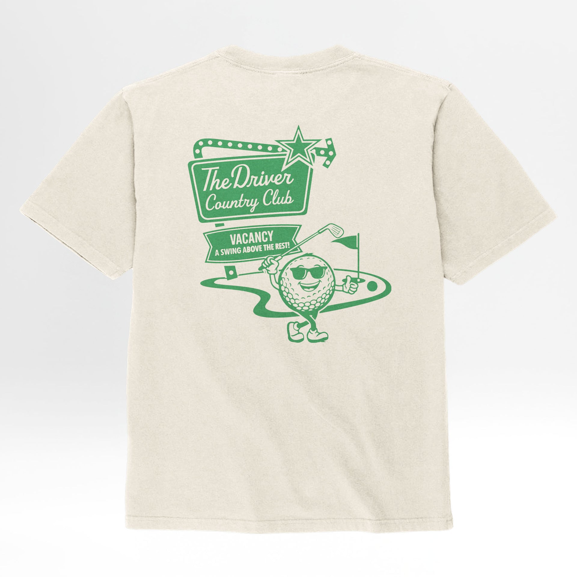 Beige t-shirt with green graphic design and text 'The Driver Country Club Vacancy A Swing Above The Rest'.