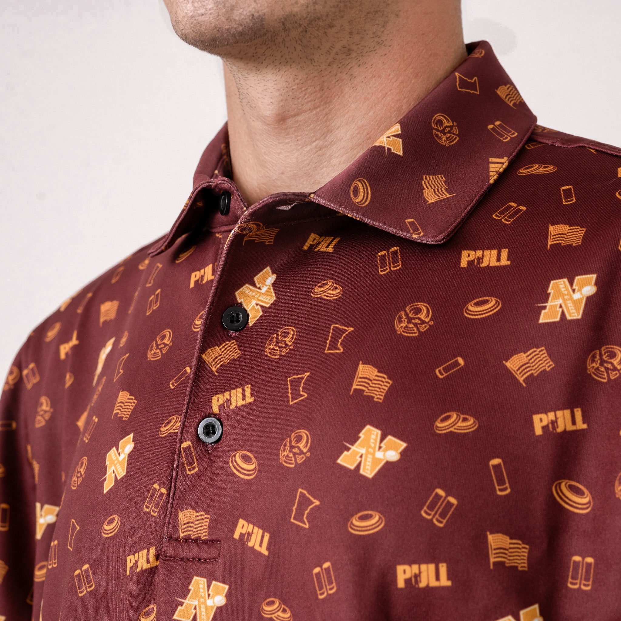 Maroon shirt with gold pattern worn by a person on a white background