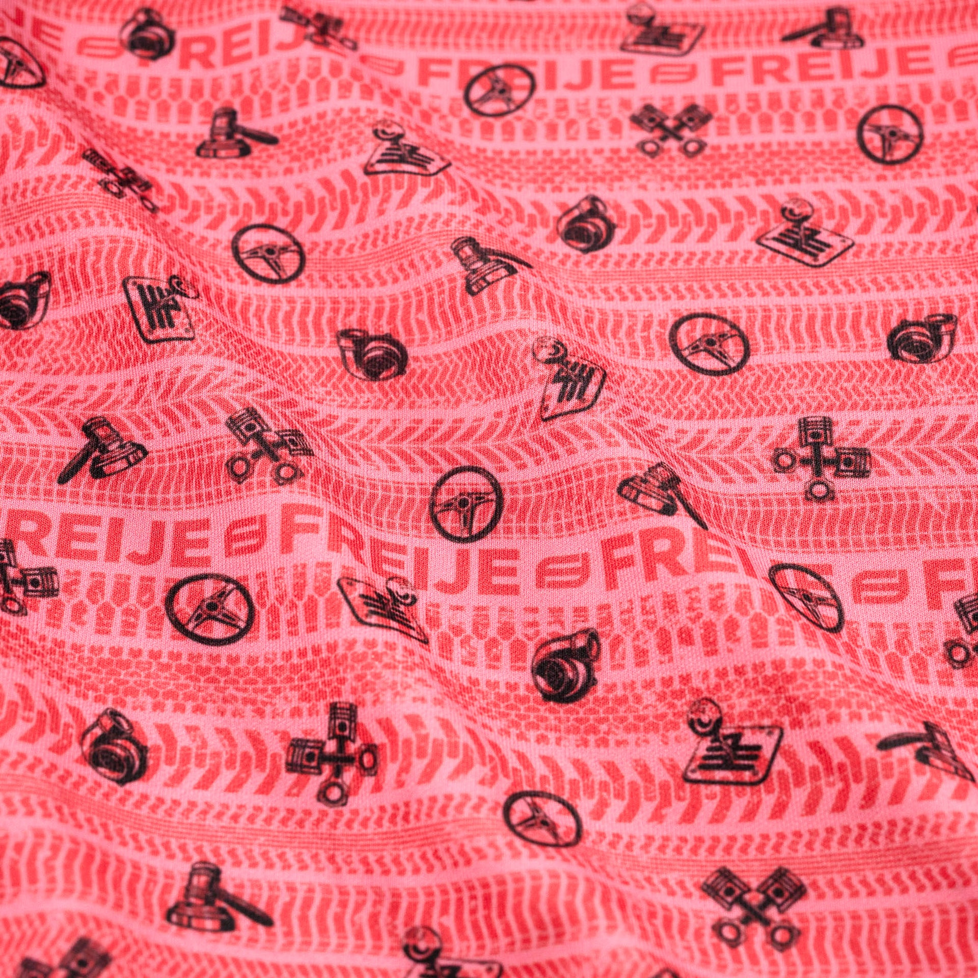 Pink fabric with red & black patterns and text on a pink background