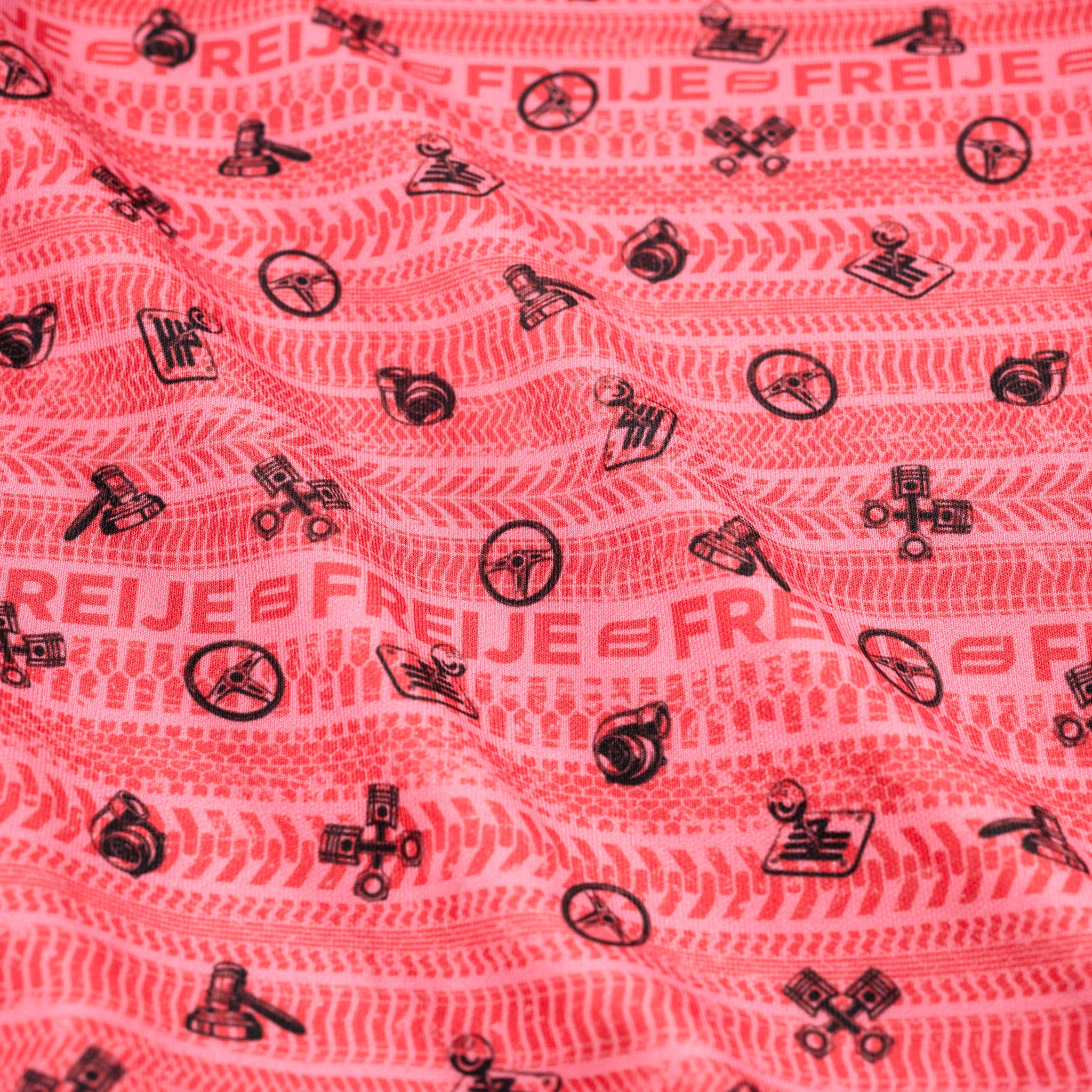 Pink fabric with red & black patterns and text on a pink background